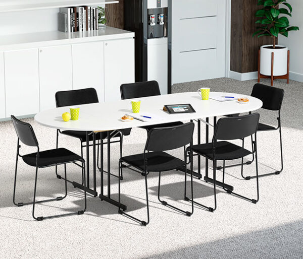konferensbord med vit skiva och svart stativ och svarta stolar.