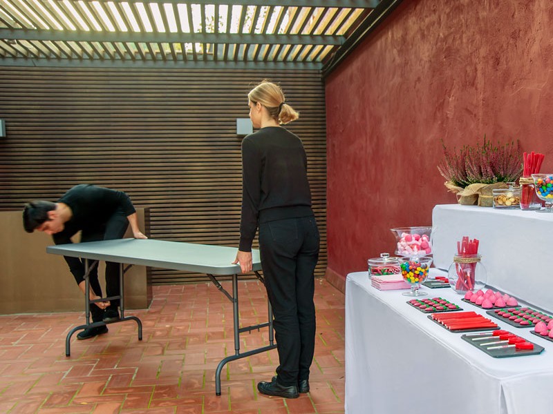 Två personer ställer upp ett Worktop 180 bord inför ett event